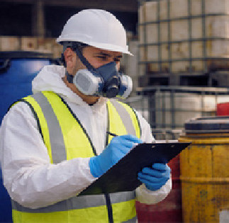 Identificación y clasificación de residuos industriales | ECOVALL Técnico de seguridad revisando y registrando residuos industriales junto a contenedores de almacenamiento