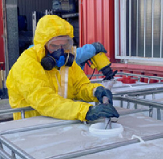 Preparación y acondicionamiento de residuos industriales | ECOVALL Operario con equipo de protección realizando el acondicionamiento de un contenedor de residuos industriales