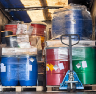 Recogida y transporte de taladrinas y aceites industriales | ECOVALL Bidones y contenedores de residuos industriales almacenados sobre palés junto a una transpaleta